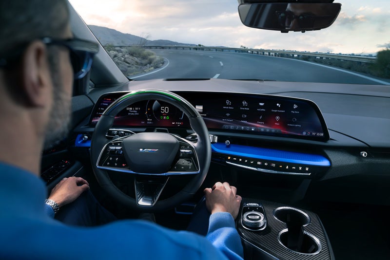 Front View of the 2026 OPTIQ-V Driving Through the Dusk Utilizing its Headlights | Palmen Cadillac in Kenosha WI